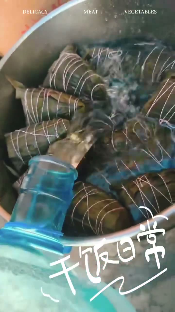Video of You Yi’s finished sticky rice dumplings (zongzi) — bundles tied in bamboo leaves boiling in a pot, then a cut-open dumpling showing the rice and filling.